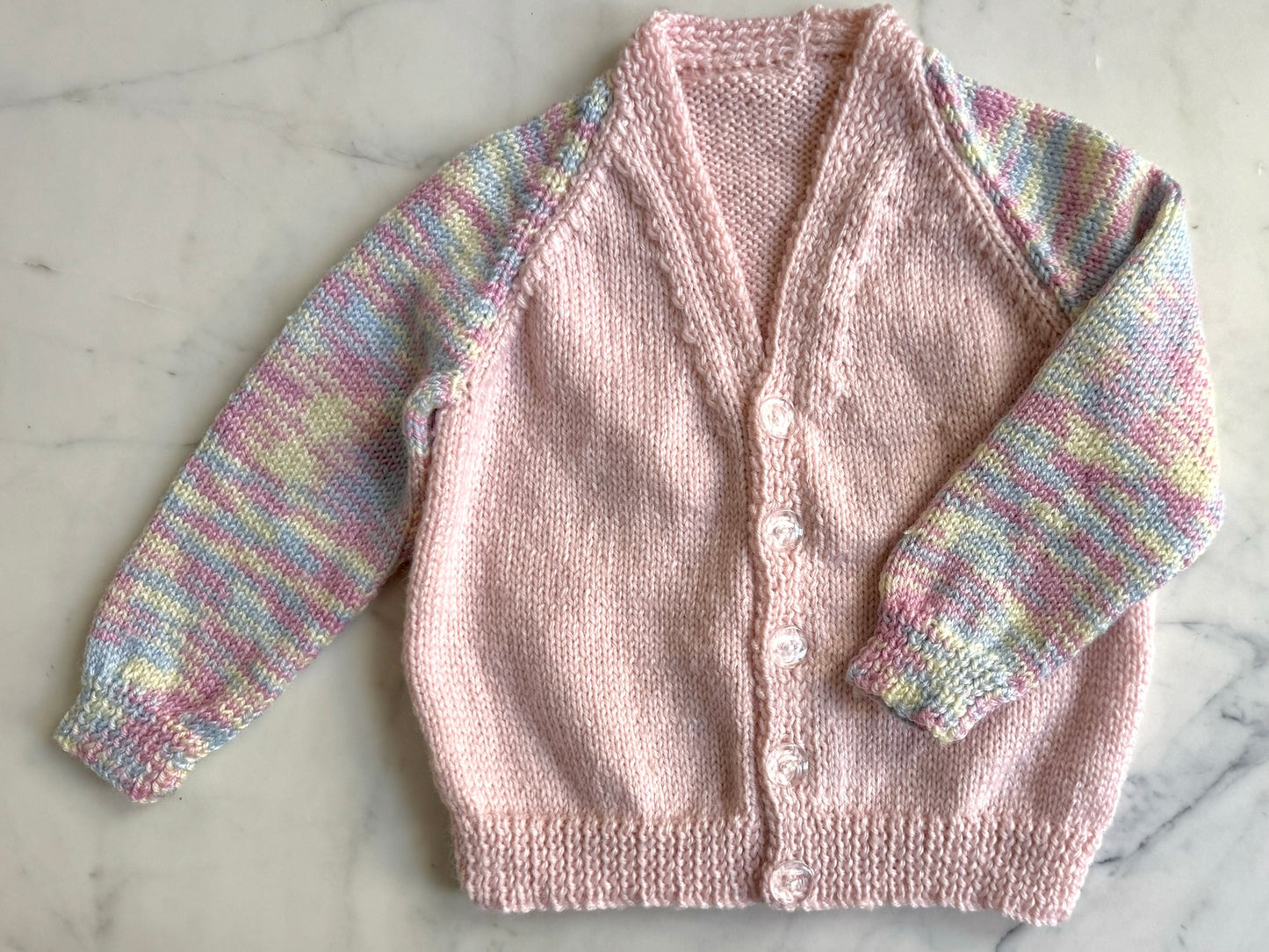 Handknitted Cardigan - 2 years Pastel Pink with Multi Rainbow arms