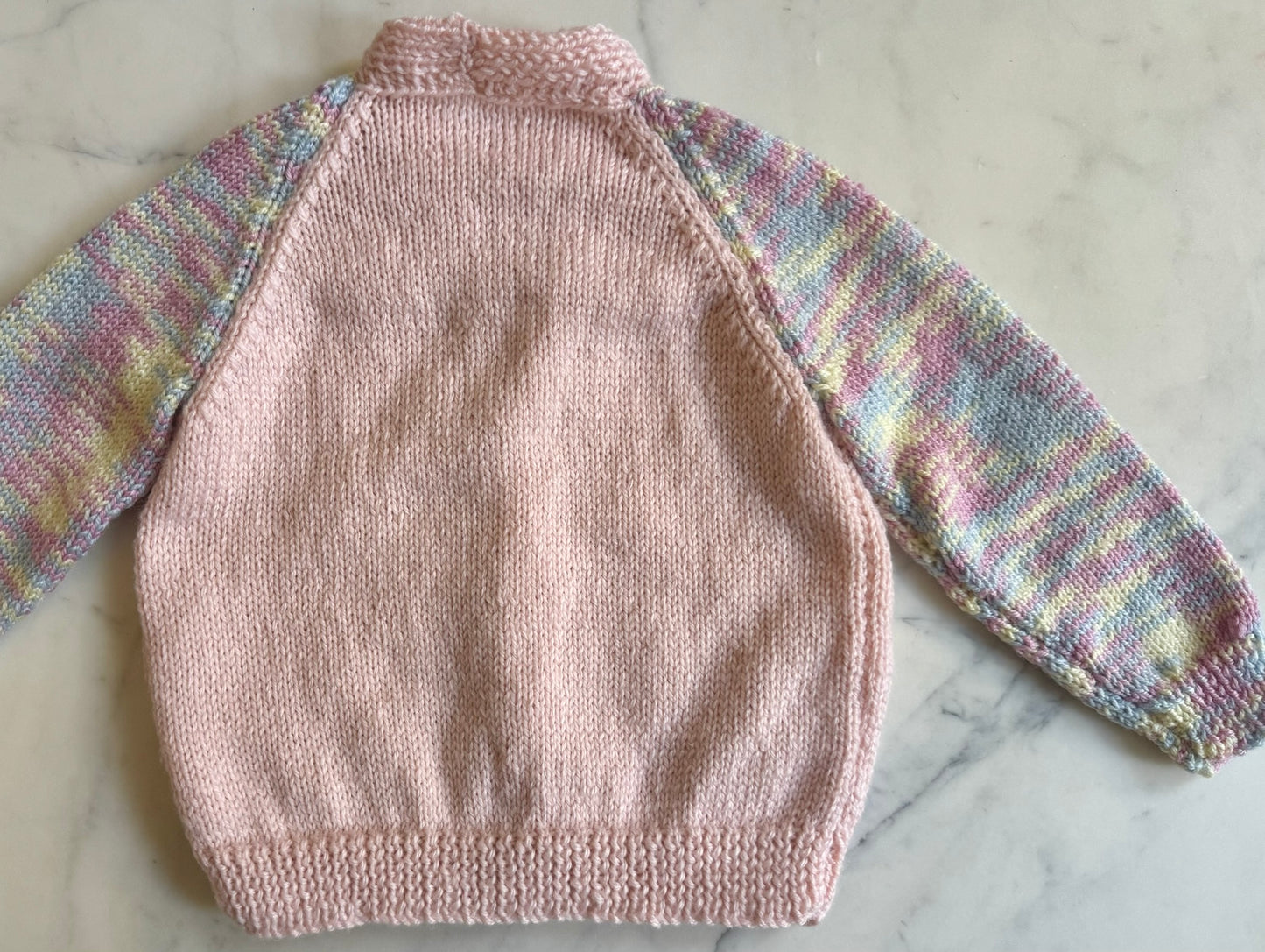 Handknitted Cardigan - 2 years Pastel Pink with Multi Rainbow arms