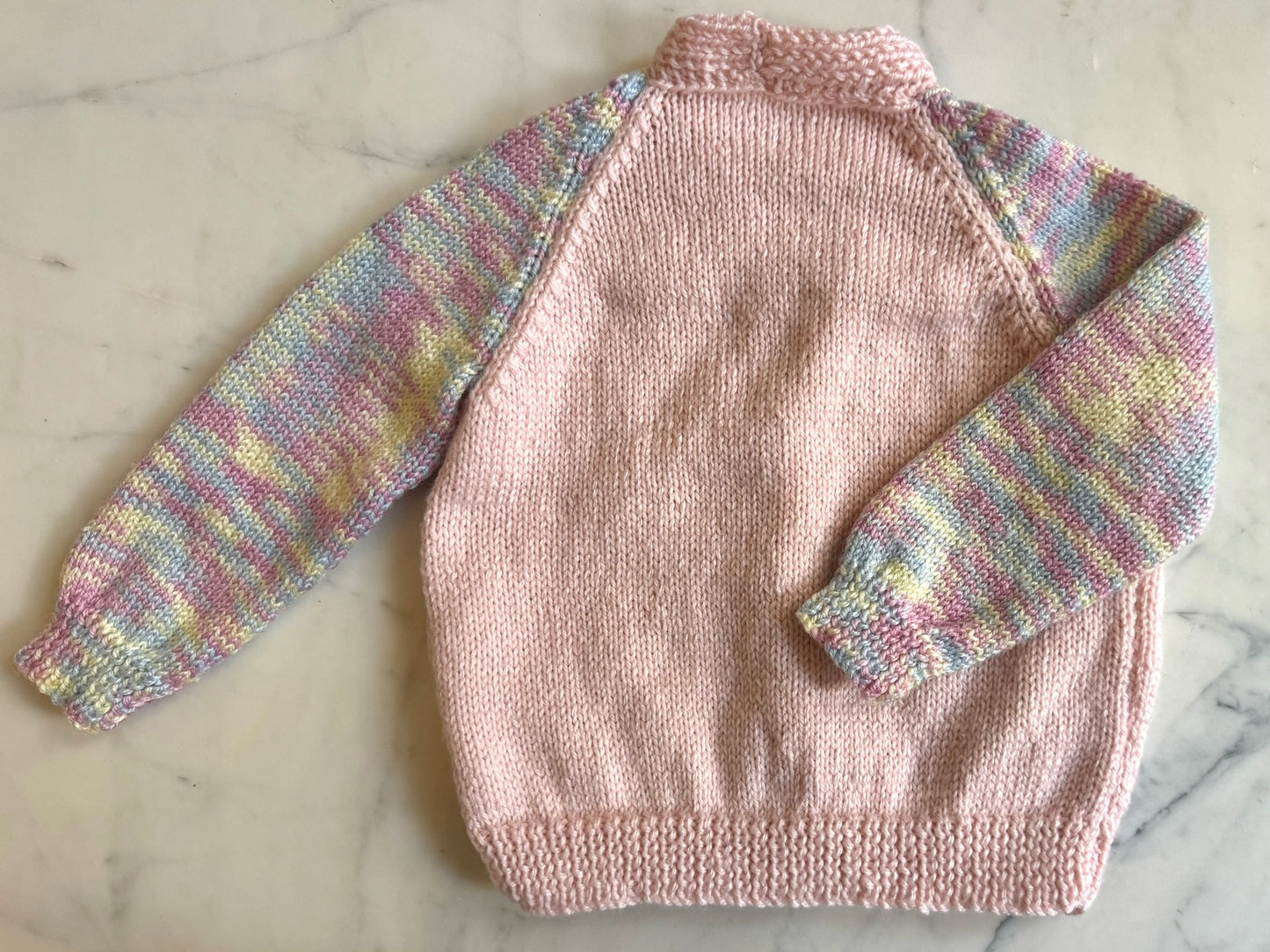 Handknitted Cardigan - 2 years Pastel Pink with Multi Rainbow arms